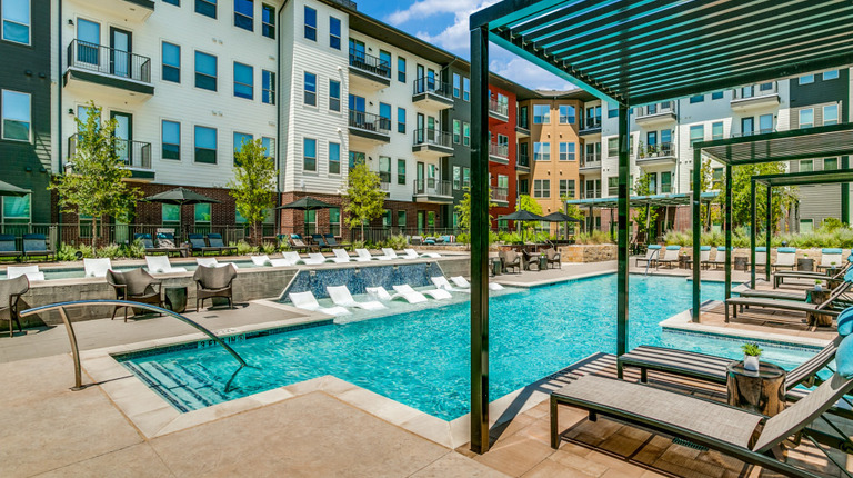 Resort-style pool with shaded lounge seating